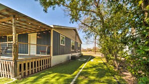 A house with a covered porch, a fenced yard, and a well-maintained lawn. - Fredricksburg Vacation Rental at 'the Loft'! (Fredericksburg)