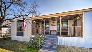 A single-story building with a porch, a flag, and a staircase leading to the entrance. - Fredricksburg Vacation Rental at 'the Loft'! (Fredericksburg)
