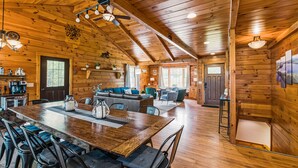 Ein geräumiges Blockhaus-Interieur mit Essbereich, Küche und Wohnzimmer.