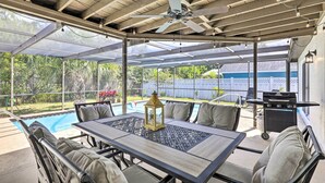 A covered patio area with a pool table, outdoor seating, a ceiling fan, and a grill. - Lavish Holiday Home w/ Lanai & Heated Outdoor Pool (Holiday)