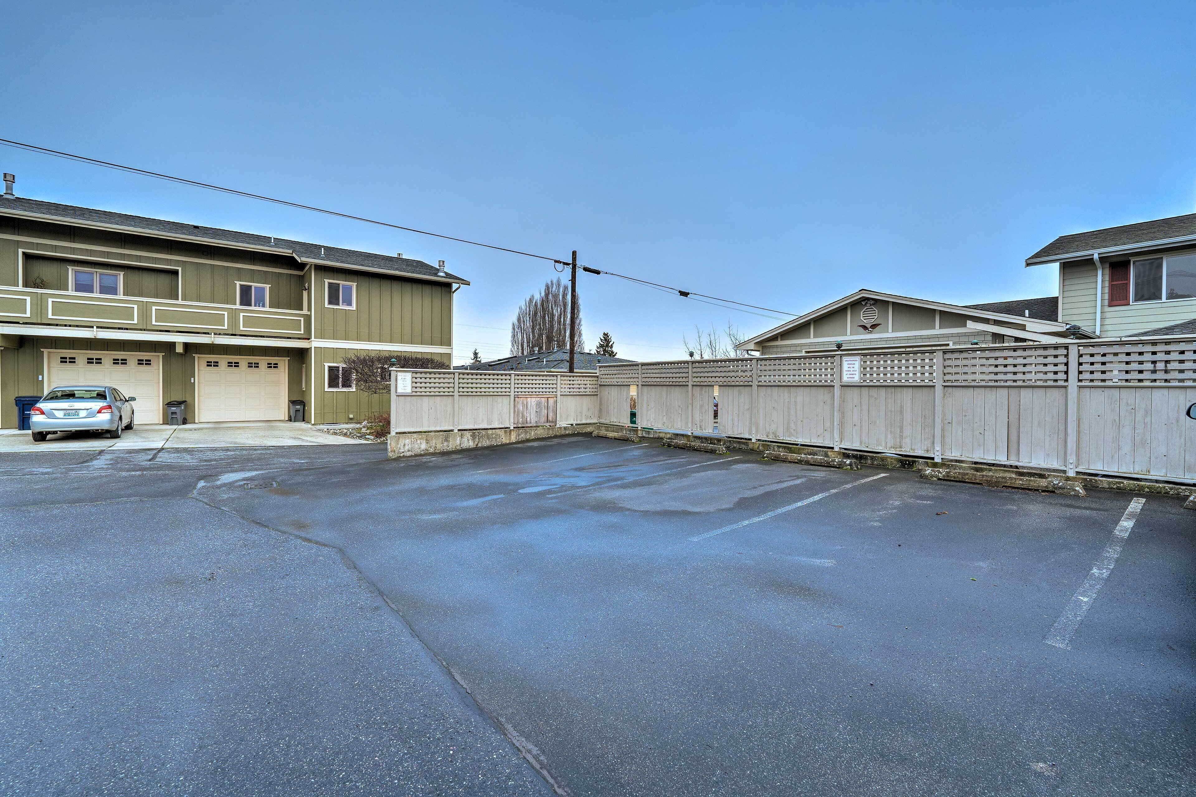 En parkeringsplats med ett staket och en byggnad med flera garageportar.
