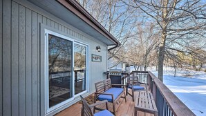 Eine Holzterrasse mit Sitzgelegenheiten und einem Grill.