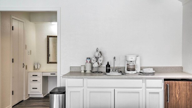 A modern kitchen with white cabinetry, a countertop, and a coffee maker. - Studio w/ Pool - 13 Mi to Downtown Dallas! (Dallas)