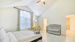 A bedroom with a bed, a crib, a ceiling fan, and a window with curtains. - 3 Mi to Kalahari: Pocono Summit Home w/ Game Room! (Pocono Summit)