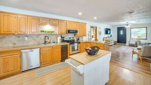 A modern kitchen with wooden cabinets, stainless steel appliances, and a central island. - Spacious Deck: Waterfront Home in Gun Barrel City! (Mabank)