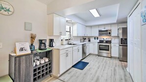 A modern kitchen with white cabinets, stainless steel appliances, and a skylight. - Bright Sebastian Home w/ Pool ~ 7 Mi to Beach! (Sebastian)