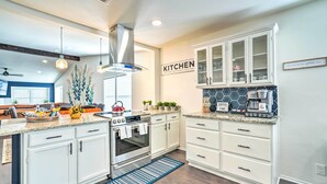 A modern kitchen with white cabinetry, a built-in oven, and a coffee station. - San Antonio Home w/ Hot Tub & Arcade Games! (San Antonio)