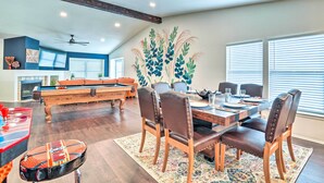 A spacious living area with a pool table, a dining table with chairs, and a large wall mural. - San Antonio Home w/ Hot Tub & Arcade Games! (San Antonio)