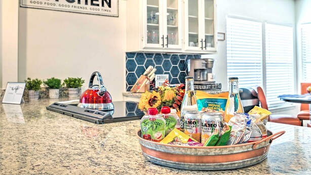A kitchen counter with a copper bowl containing various food items and a red kettle. - San Antonio Home w/ Hot Tub & Arcade Games! (San Antonio)