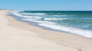 Ein Strand mit blauem Himmel und ruhiger See.