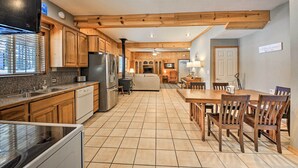 A spacious kitchen with wooden cabinets, a dishwasher, and a large dining table with chairs. - Family-friendly Sagle Vacation Rental w/ Deck (Sagle)