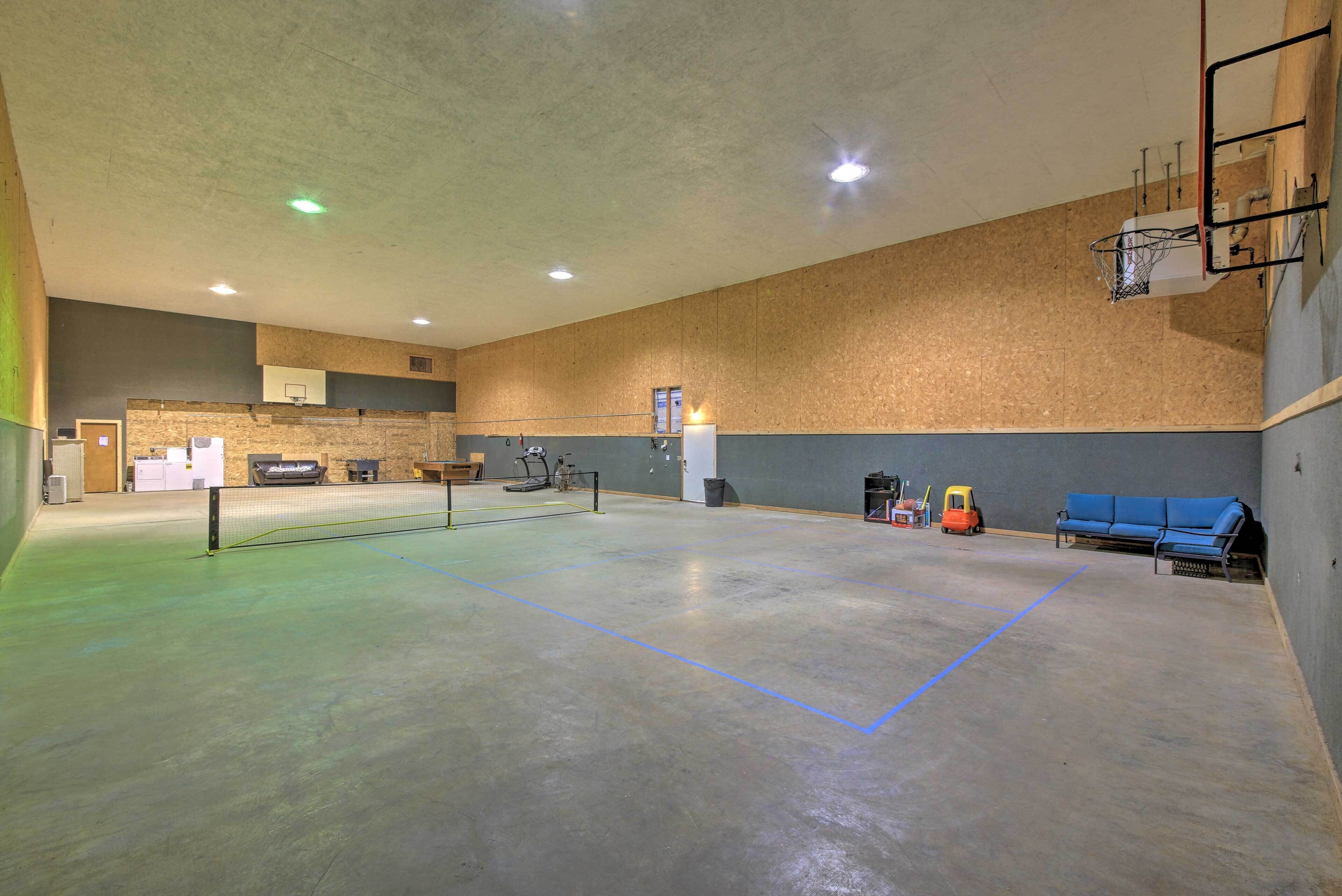 An indoor sports facility with a basketball court, exercise equipment, and seating areas.