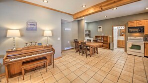 A spacious living area with a piano, dining table, and kitchen area. - Family-friendly Sagle Vacation Rental w/ Deck (Sagle)