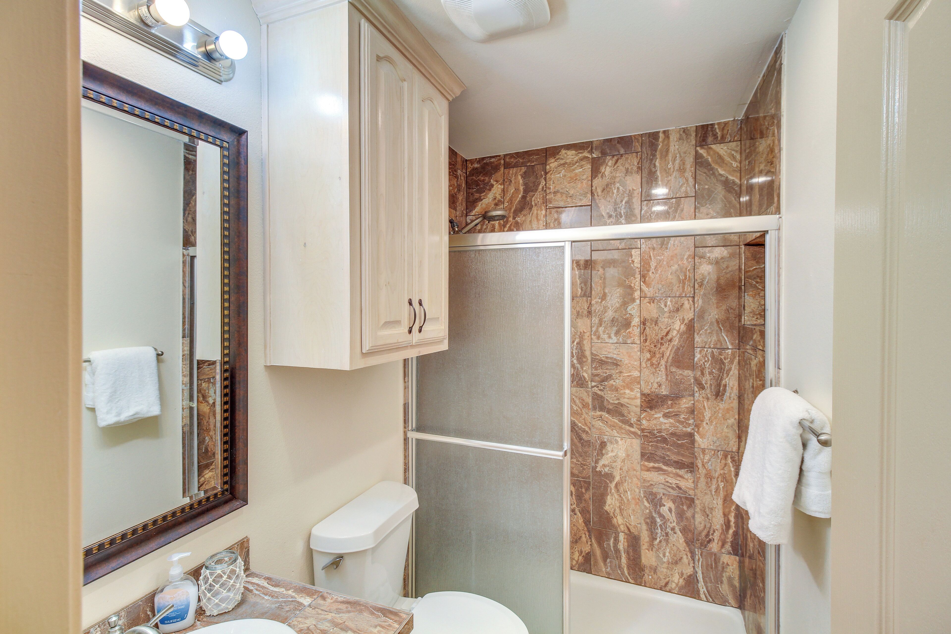 Un baño con ducha, inodoro y lavabo.