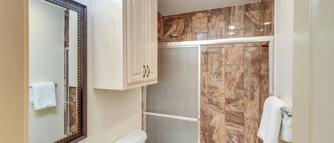 Un baño con ducha, inodoro y lavabo.
