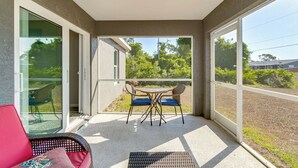 A room with a glass door leading to a patio, a ceiling fan, and a table with chairs.