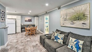 A compact living space with a kitchenette, a dining area, and a seating area with a sofa and cushions. - Walk to Ocean: Condo w/ Community Perks on HHI (Hilton Head Island)