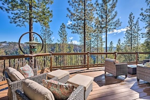A wooden deck with wicker furniture and a hanging light fixture.