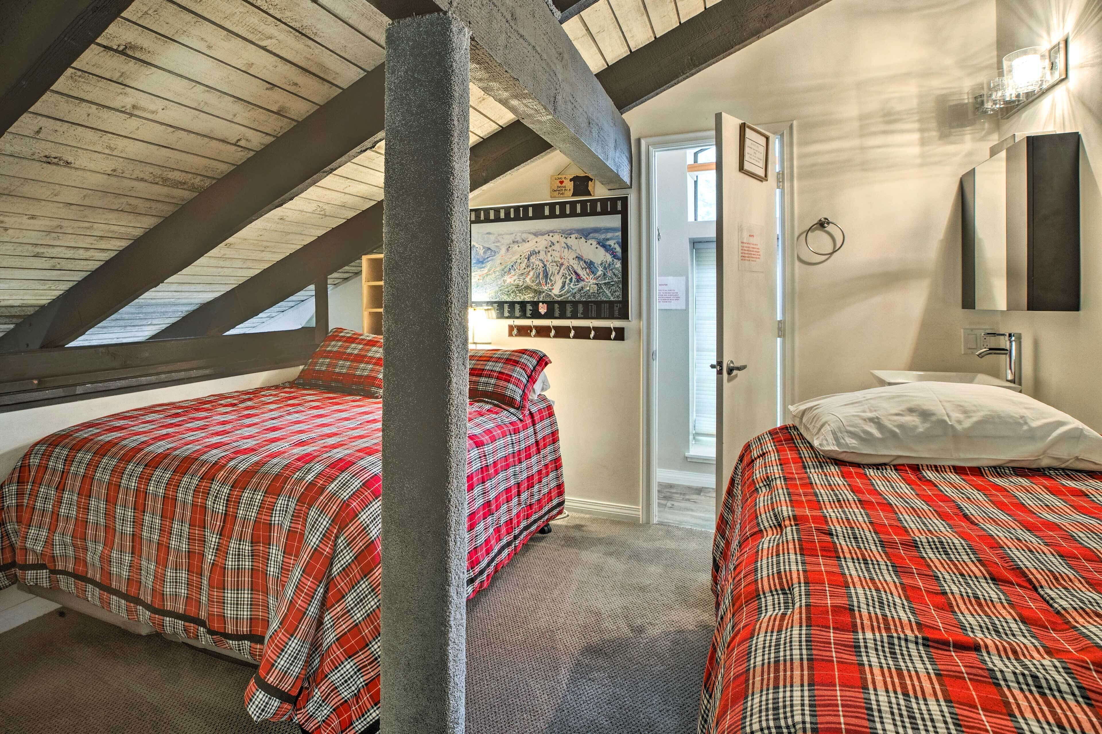 Ein Zimmer mit zwei Betten, einer Holzbalkendecke, einem Gemälde und einer Tür.