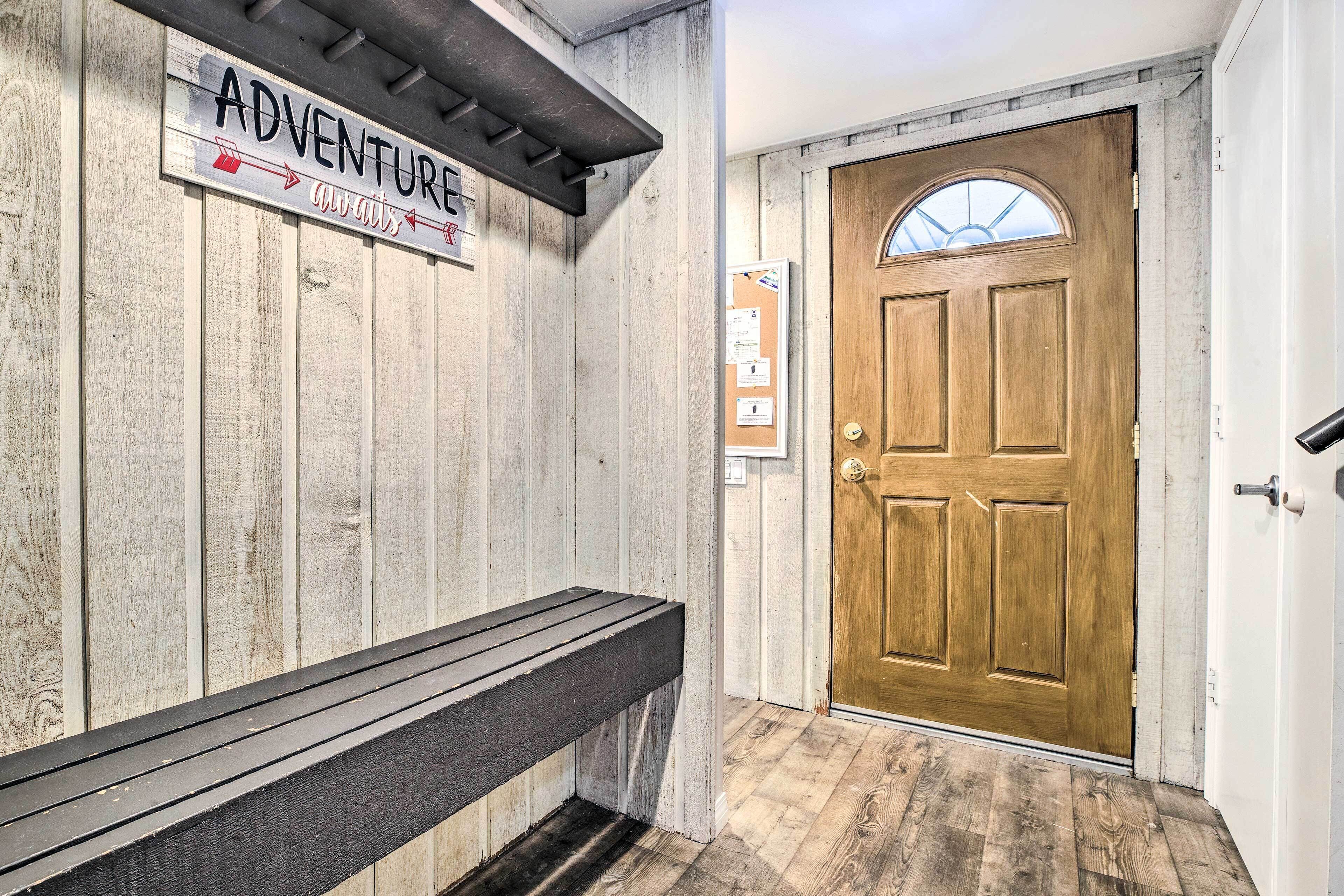 A wooden bench, a wooden door, and a wall with a sign that reads "ADVENTURE always".