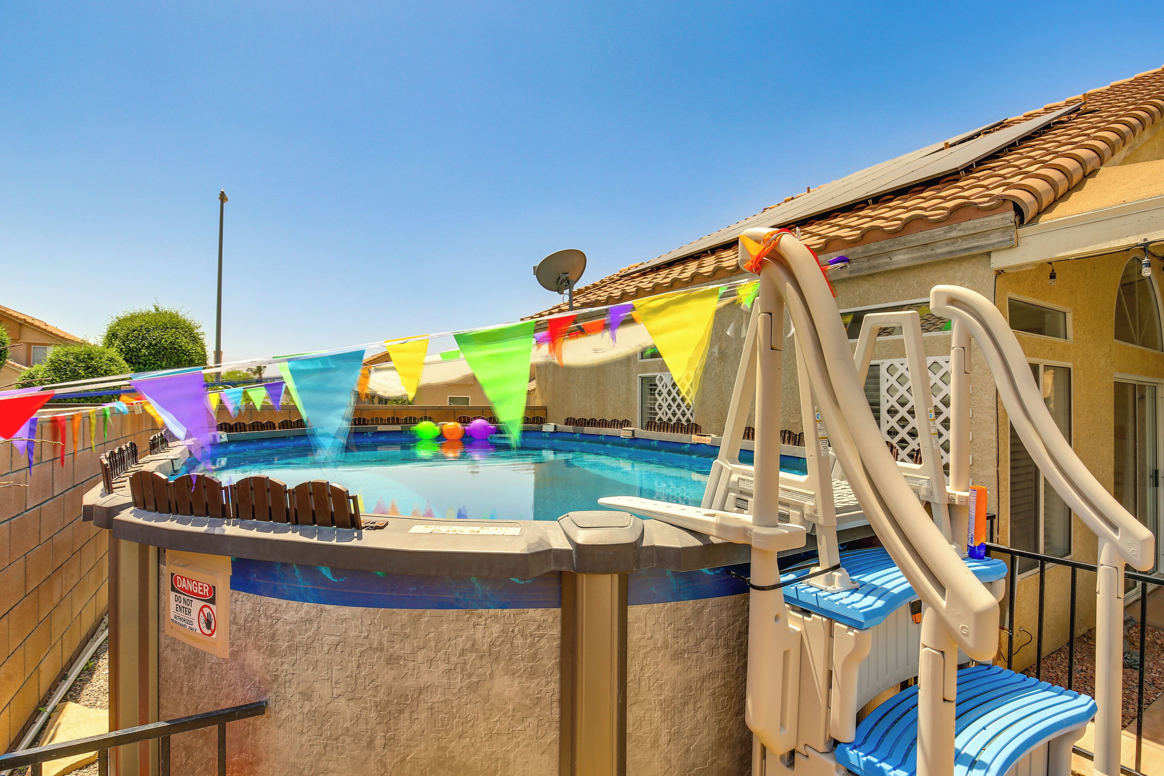 A backyard with a hot tub, a slide, and a pool.