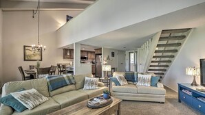 A spacious living room with a large sofa, a coffee table, and a staircase leading to an upper level. - Pagosa Springs Condo Near Springs + Trails! (Pagosa Springs)