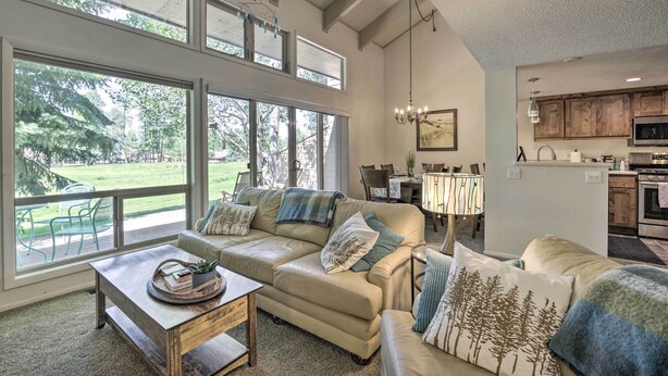 A spacious living room with a large window, a dining area, and a kitchen. - Pagosa Springs Condo Near Springs + Trails! (Pagosa Springs)