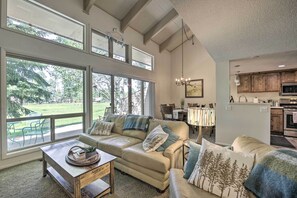 Un salón amplio con un gran ventanal, zona de comedor y cocina.