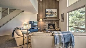 A living room with a fireplace, a television, and a sofa. - Pagosa Springs Condo Near Springs + Trails! (Pagosa Springs)