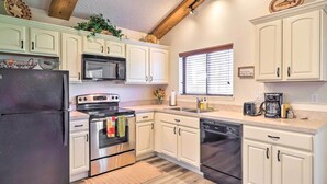 A kitchen with white cabinets, stainless steel appliances, a microwave, oven, and dishwasher. - Cozy Pagosa Springs Townhome w/ Patio! (Pagosa Springs)