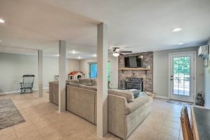 A spacious living room with a fireplace, a large TV, and a dining area.