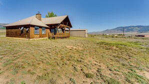 A rustic wooden building with a large porch and a metal shed in a rural setting. - New Mexico Cabin Hideaway w/ Eagle Nest Lake Views (Eagle Nest)