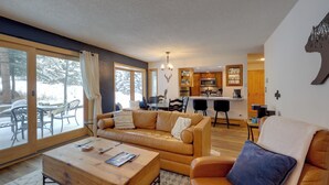 En moderne stue med sofa, sofabord og spiseområde med stole.