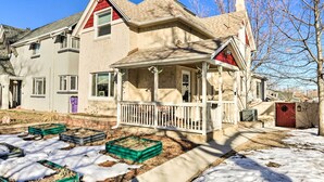 A two-story house with a porch, a red door, and a garden with raised beds. - 3 Mi to Dtwn: Convenient Denver Apt (Denver)