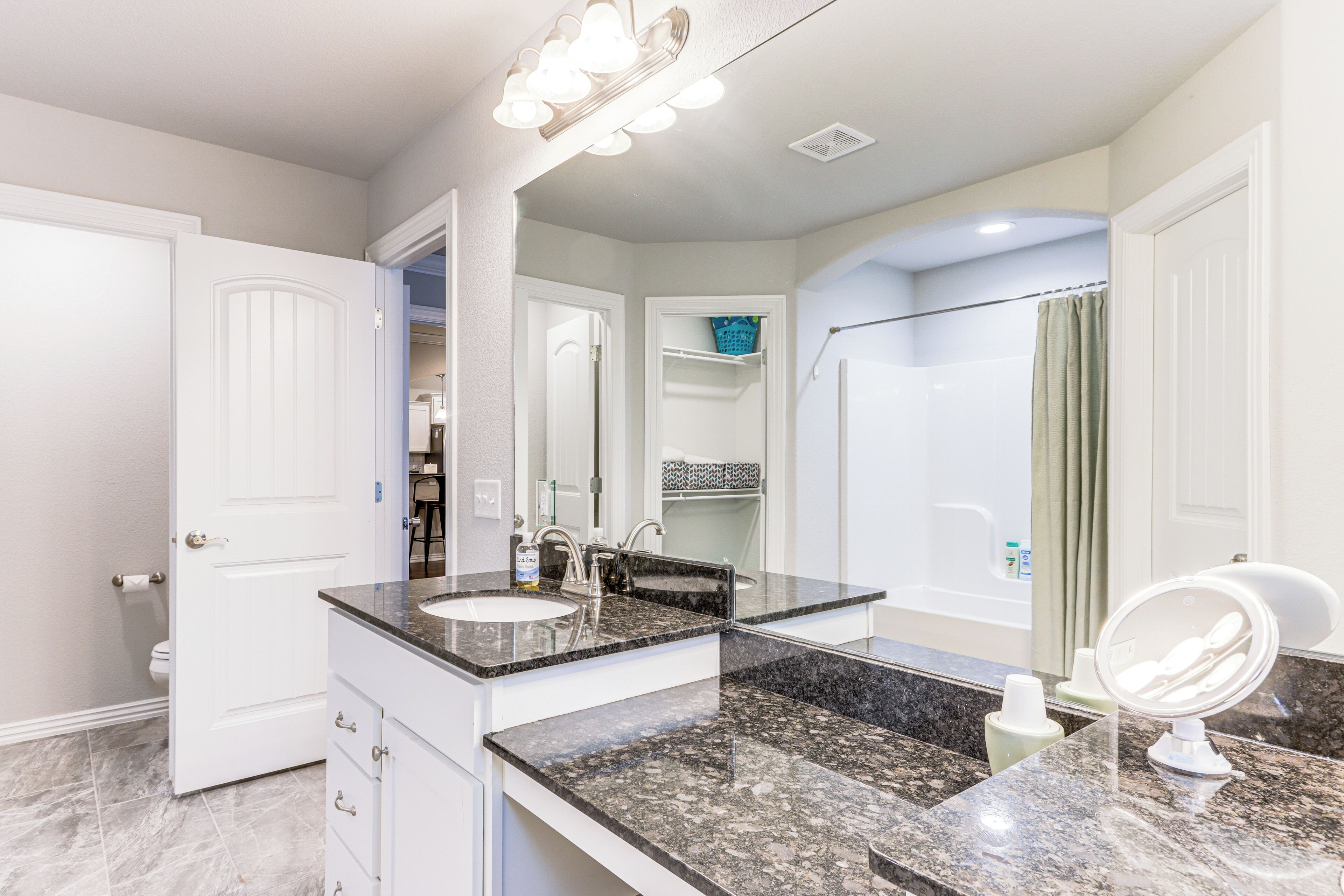 A modern bathroom with a double sink, vanity, and a large mirror.