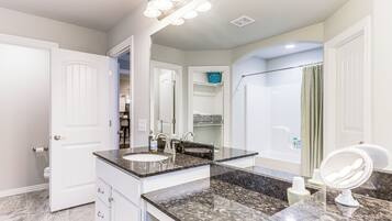 A modern bathroom with a double sink, vanity, and a large mirror.