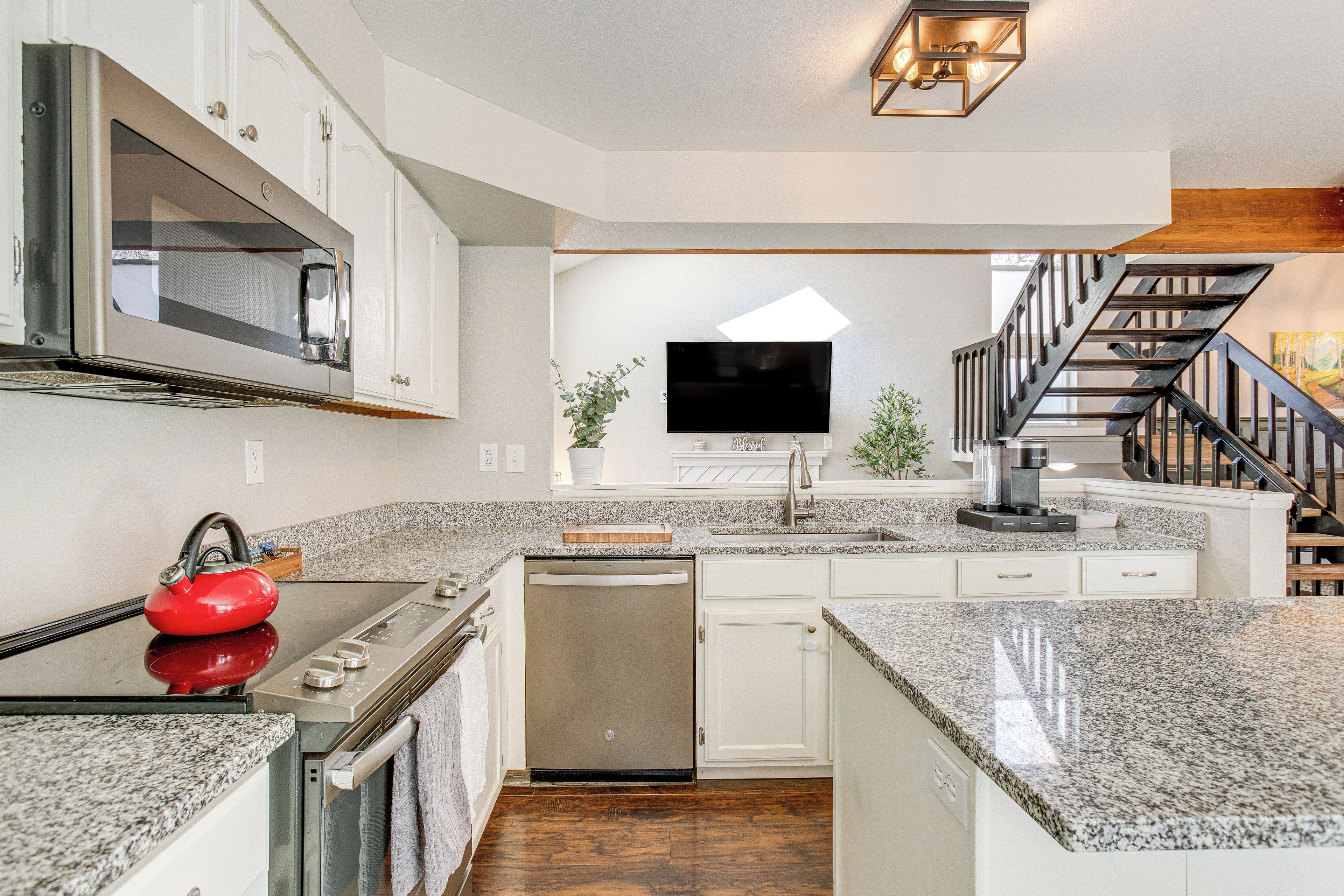 A modern kitchen with granite countertops, stainless steel appliances, and a built-in dishwasher.