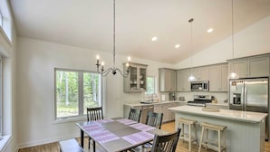 A modern kitchen with a large island, built-in appliances, and ample natural light from large windows. - Door County Family Home: 3 Mi Whitefish Dunes (Sturgeon Bay)