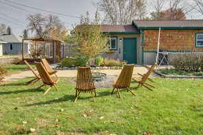 A backyard with four wooden chairs arranged in a semi-circle, a wooden deck, and a house with a green door and windows. - Fish, Hike & Mtn Bike: Ironton Escape w/ Fire Pit (Ironton)