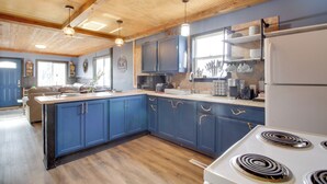 A modern kitchen with blue cabinets, a white stove, and wooden ceiling beams. - Quaint Ironton Getaway w/ Fire Pit, Gas Grill! (Ironton)