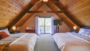A bedroom with two beds, a ceiling fan, a window with curtains, and a nightstand with a lamp. - Spacious Groveland Cabin w/ Wraparound Deck! (Groveland)