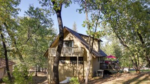 A cabin with a balcony, surrounded by trees and a clear sky. - Spacious Groveland Cabin w/ Wraparound Deck! (Groveland)