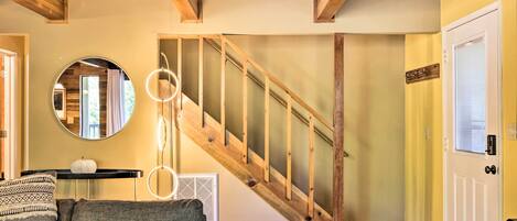 A staircase with wooden railings and a circular mirror on the wall.