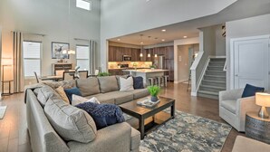 A spacious living room with a sectional sofa, a coffee table, and a kitchen in the background. - Granby Golf Retreat w/ Ski Trails, Mountain View! (Granby)