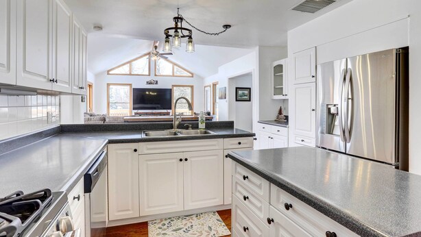 A modern kitchen with white cabinets, stainless steel appliances, and a large island. - Centennial Home w/ Game Room, 11 Mi to Downtown! (Littleton)