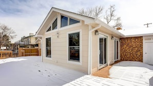 A two-story house with a covered deck and a brick wall. - Centennial Home w/ Game Room, 11 Mi to Downtown! (Littleton)