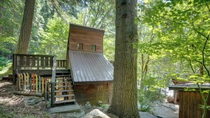 A rustic cabin with a sloped roof, wooden deck, and a small staircase leading to the entrance. - Leavenworth Cabin w/ Private Hot Tub! (Leavenworth)