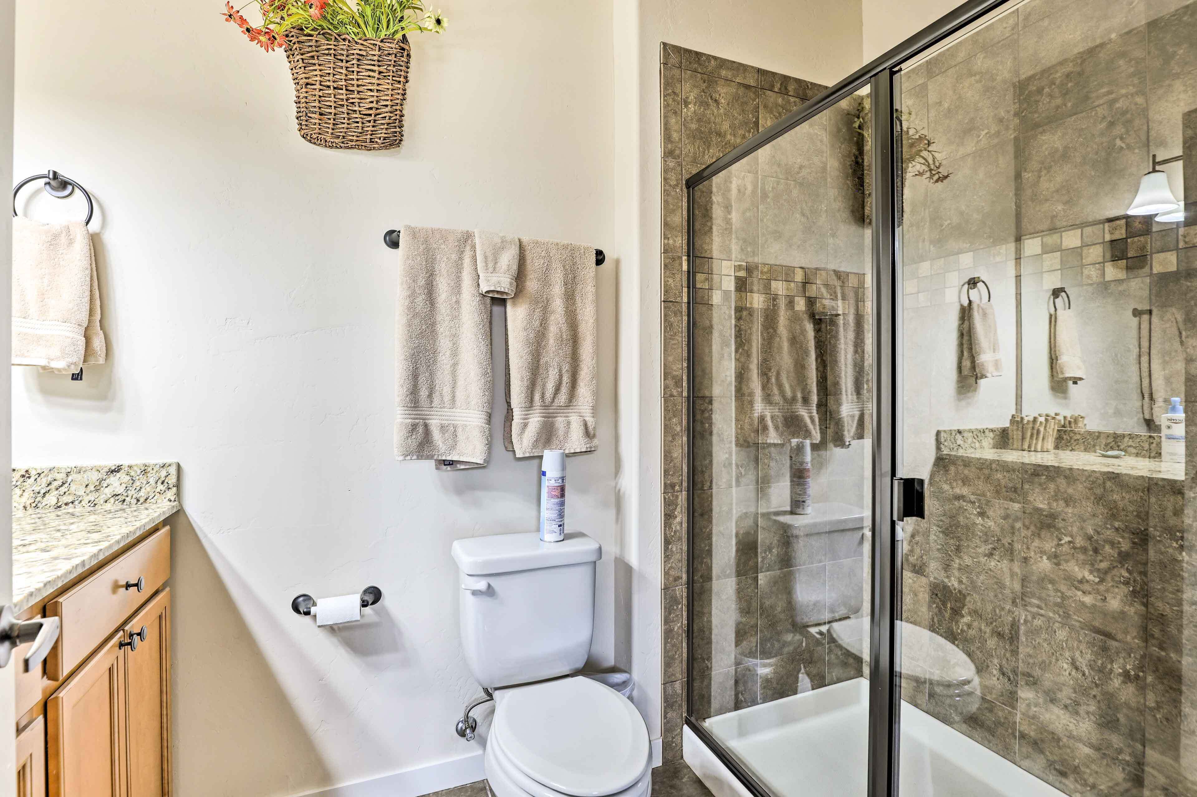 Une salle de bain comprenant des toilettes, une douche en verre et un lavabo.