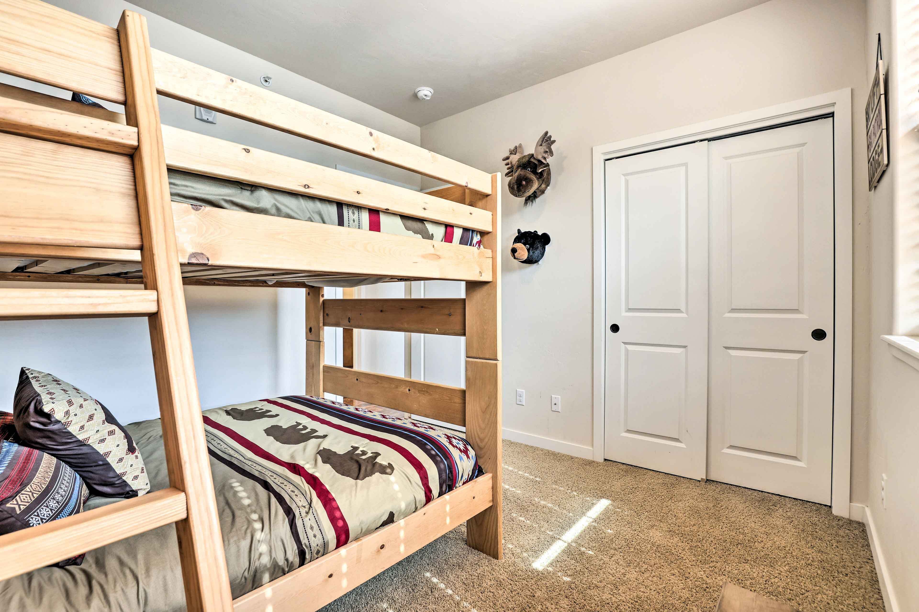 Ein Stockbett mit einer Leiter, eine Tür mit Schlüsselloch und ein an der Wand befestigter Tierkopf.