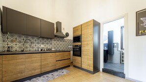 A modern kitchen with wooden cabinets, a patterned backsplash, and built-in appliances.